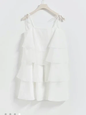 Vit volangklänning med knytband - Säljer min fina klänning från Gina då den ej kommer till användning. Passar perfekt till student eller skolavslutning. Köptes för 700 och har endast använts en gång. På sista bilden i mitten ser man klänningen på.
