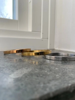  Armband i metall - Snygga armband  i tre olika färger: guld, silver och roséguld. De är stela och har ingraverad logga runt om. Perfekta för att ge din outfit en lyxig touch. Tillverkade i metall med stilren och modern design och färgen går inte bort kan hade den jätte länge 