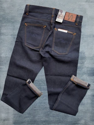 *Nya* SELVAGE Nudie Lean Dean - Ett par sprillans nya nudie jeans gjorda i selvedge av högsta kvalitet med alla tags kvar! Priset i butik ligger på 2000 kr. Modellen ”Lean Dean” har en mycket trevlig slimfit passform men materialet gör att det snarare blir slim/straight! Storlek 30/32 - Hör av dig vid frågor!