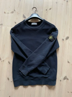 Mörkblå sweatshirt från Stone Island - Mörkblå sweatshirt från Stone Island i storlek L.  Några få defekter på ärmarna men annars i bra skick.                                                                        Skön passform och lätt att stylea.                      Scan finns. 