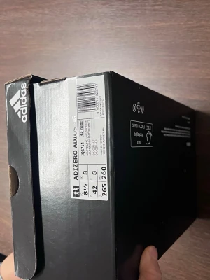 Adidas Adizero Adios 3G löparskor - Säljer ett par Adidas Adizero Adios 3G löparskor i vitt meshmaterial med silver- och gula detaljer. Skorna har klassiska tre ränder på sidan, slitstark yttersula med blå och gula inslag samt ventilerande ovandel. Perfekta för dig som gillar stilrena och lätta sportskor.