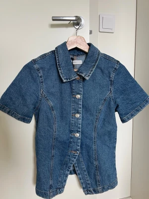 Kortärmad jeansskjorta - Snygg kortärmad skjorta i blå denim. Använd en gång. 