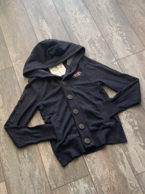 Hollister cardigan archive  - Säljer en riktig snygg Hollister Cardigan Hoodie. Denna är väldigt välkänd och många som söker. Den är sällsynt och snygg. Skicket är 10/10. Storlek är S. Priset kommer ligga på 699kr.