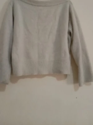 Ljusgrå stickad tröja Gina Tricot - Mysig ljusgrå stickad tröja från Gina Tricot med bred ribbstickad kant nedtill och vid ärmsluten. Tröjan har en enkel, rak passform och är tillverkad i ett mjukt material som passar perfekt till kyliga dagar.