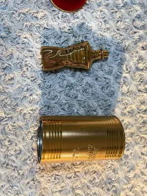 Jean Paul Gaultier Le Male Le Parfum - Säljer en Jean Paul Gaultier Le Male elexir absolu i en unik guldfärgad flaska formad som en manlig torso på 75ml,skulle gissa på 73ml vid nuläget. Flaskan är metallisk och kommer med en matchande guldfärgad metallburk som förpackning. Perfekt för dig som gillar lyxiga och ikoniska dofter. Knappt använd.