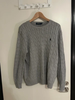 Grå Knitted Ralph Lauren sweater - Säljer min gråa Ralph Lauren tjocktröja. Väldigt gott skick inget slitage. Storlek M. 100% bomull. Nypris ligger på 2000kr