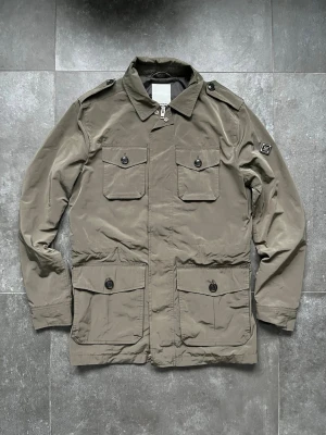 J.lindberg field jacka  - Tjena, säljer nu denna riktigt snygga och populära J.lindberg field jackan, den är i nyskick, inga skador, färg: khaki glansaktig, sitter stort i storleken, hör av er vid frågor och funderingar🙌🤝 