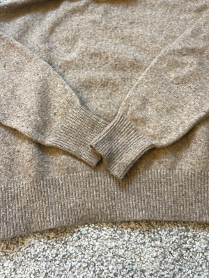 Beige stickad tröja Gina Tricot - Mysig beige stickad tröja från Gina Tricot i storlek XXS. Tröjan har ribbstickade muddar vid ärmslut och nederkant, och är tillverkad i ett mjukt material som passar perfekt för kyligare dagar.