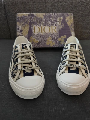 Dior dam sneakers 39/38 - Säljer ett par Dior sneakers i storlek 39. Skorna är endast provade inomhus då de tyvärr var för stora för mig. De är alltså i nyskick. Modellen är en normal 39 men upplevs något liten, skulle även kunna passa dig som har 38. Väldigt snygga och stilrena, lätta att matcha till olika outfits. Originalkartong medföljer.  Info:     •    Dior sneakers     •    Storlek 39 (passar även 38)     •    Endast provade     •    Nyskick     •    Blå/vit med Dior-mönster     •    Originalkartong ingår