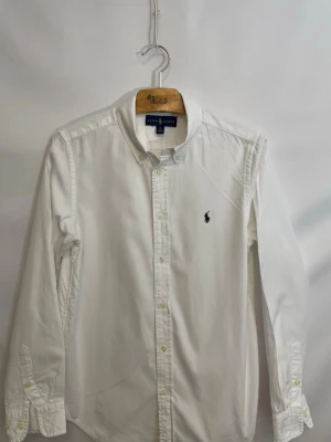 Vit skjorta från Ralph Lauren - Vit skjorta från Ralph Lauren, storlek 18.  Mycket fint skick! Liten reva i sömmen i själva skjortan som knappt syns och inte påverkar något alls, se sista bild😊