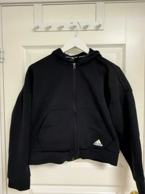 Adidas kofta  - Svart adidas kofta med detaljer längst ryggen. 