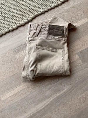 Replay anbass - Snygga beige jeans från Replay med raka ben och klassisk femficksdesign. Jeansen har en diskret logga på bakfickan och patch med Replay Jeans Original på linningen. Tillverkade i mjukt bomullsmaterial för skön känsla. Storlek 29/32