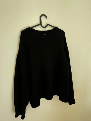 Svart oversized stickad tröja - En svart, oversized stickad tröja med rund hals och långa ärmar. 