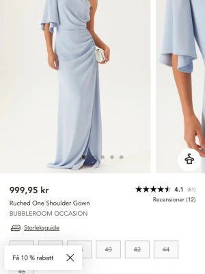 Balklänning  - Elegant ljusblå långklänning från Bubbleroom, med one shoulder-design och draperad detalj i sidan. Klänningen har en lös ärm på ena sidan och en figurnära passform som ger en stilren siluett. Perfekt för speciella tillfällen.kan även skicka egna bilder om du är intresserad. Helt oanvänd men lappen kvar. Kan även visa de om man frågar 💕pris går att diskutera vid snabb affär 