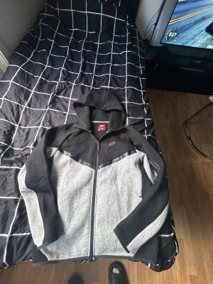 Nike Tech Fleece Hoodie/Ställ – Strl S – Fint skick 🔥 - Säljer en snygg och bekväm Nike Tech Fleece hoodie/jacka i storlek S. Använd endast 3–4 gånger och är därför i väldigt fint skick utan några skador, hål eller fläckar. Perfekt för både vardag och träning.  * Märke: Nike * Modell: Tech Fleece * Storlek: S * Färg: Svart/Grå * Material: 80% Cotton * Skick: Nästan som ny * Använd: 3–4 gånger * Inga skador * Pris kan diskuteras vid snabb affär  Passar perfekt till streetwear, gym eller casual outfits.