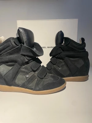Isabel marant wedge sneakers svart  - Säljer dessa Isabel marant wedge sneakers becket i färgen svart. Dem är i super bra skick endast använda ett par fåtal gånger. Säljer dem då dem inte kommit till användning. Orginal kartong och dustbag tillkommer. Bara att skriva vid frågor 😊❣️