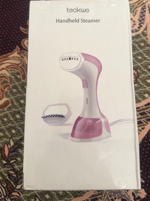 Teckwe Handheld Steamer rosa/vit - Säljer en Teckwe Handheld Steamer i rosa och vitt. Perfekt för att snabbt och smidigt ånga kläder och ta bort skrynklor. Kommer med ett borsttillbehör för extra funktionalitet. Enkel att använda och smidig att ta med på resan. Helt ny!