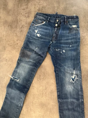 Blå slitna jeans från dsquared2 - Jeansen är lite söndriga vid rumpan men går att fixa för 200 kr och därav billigare pris !! 