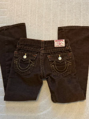 True Religion Limited Ed Bruna Jeans - Ett par limited edition (enligt förra ägare) true religion jeans som passar en liten person runt 150-155 cm💓 köpte dessa o trodde de passa men har svårt vid att få de på🥹 var synd för tyckte annars de var jätte söta. Vid intresse känn dig bekväm med att skriva. Köpare står för frakt💓