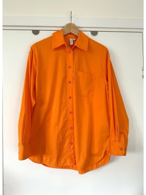 & Other Stories - Orange oversize skjorta - storlek XS / S - Härlig oversize skjorta i en livlig orange nyans från & Other Stories i storlek XS (men är oversize, passar större också, men då lite mer figurnära). Tidlös modell med långa ärmar, klassisk krage och knäppning framtill. Skjortan har en bröstficka och manschetter med knappar. 100% bomull, så bra material som andas. Kvalitetsskjorta som passar till alla sammanhang. Nypris 890:-. Mycket gott skick, som ny!