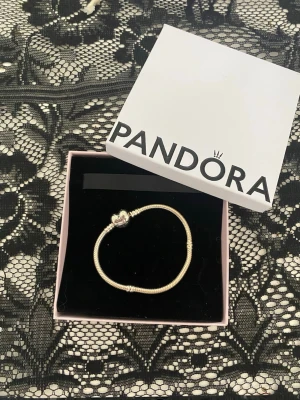 Pandora silverarmband med hjärt spänne  - Otroligt fint och snyggt Pandora armband i silver. Hjärtformad spänne. I storlek 17. Fick i julklapp julen 2025, och aldrig använt. Är även öppen till att byta mot samma modell fast i guld💕 