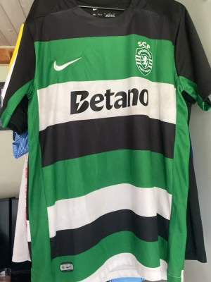 Sporting CP Gyökerers 9 - Sporting CP:  matchtröja från 24/25 från Nike med tryck med sponsorloggor, klubbmärke och nummer 9 med namnet Gyökeres på ryggen. Den är använd en gån men klubbmärket har lossnat lite men går förmodligen o limma fast igen där av priset👍