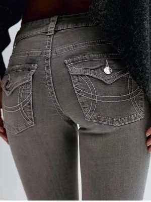 Grå bootcut jeans med fickdetaljer - Gina tricot Snygga grå bootcut jeans med markerade sömmar och coola fickdetaljer bak. Jeansen har låg midja, klassisk femficksdesign och är tillverkade i stretchigt denim för en bekväm passform. 