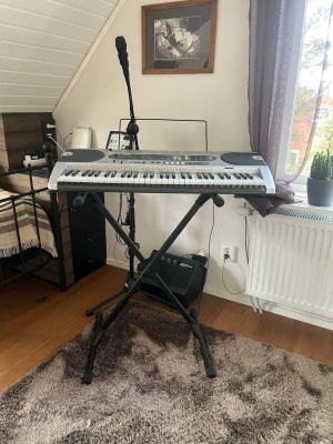 Casio keyboard med stativ  - Elektroniskt keyboard från Casio i silver och svart med inbyggda högtalare, LCD-display och flera kontrollknappar.  Keyboard och stativ kan säljas separat. 