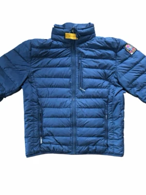 Blå dunjacka från Parajumpers - Snygg blå dunjacka från Parajumpers med quiltad design, hög krage och dragkedja framtill. Jackan har tre fickor med dragkedja och en patch med logga på ena ärmen. Perfekt för kalla dagar och enkel att matcha med olika outfits. Mer svart i färgen