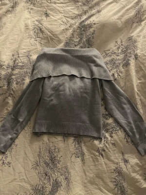 Ljusblå off shoulder stickad tröja - Snygg ljusblå stickad tröja med off shoulder-design och bred ribbad kant upptill. Tröjan har långa ärmar och ribbade muddar vid ärmslut och nederkant. Perfekt för dig som gillar en trendig och avslappnad look. Materialet är väldigt mjukt och stretchigt. Tröjan är helt oanvänd och prislappen är kvar! Passar bra på mig som vanligtvis har xxs/xs.