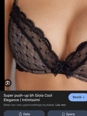 Svart push-up bh från Intimissimi - Snygg svart push-up bh från Intimissimi med spetsdetaljer och prickigt mesh-tyg. Bh:n har dekorativ rosett framtill och vadderade kupor som ger extra lyft. Axelbanden är justerbara för bästa passform. Köpt här på plick men är för liten för mig🥰