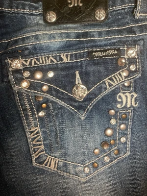 Miss Me blå jeans med nitar och pärlor - Ett par miss me jeans i mycket bra skick som säljs pågrund av att jag bytt stil, dom har fina detaljer och är blåa. Nypris 2500kr