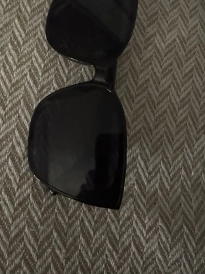 Svarta solglasögon med bred båge - Snygga svarta solglasögon med bred, fyrkantig båge och mörka glas. Klassisk och stilren design som passar till de flesta outfits. Perfekta för soliga dagar när du vill ha en cool look.