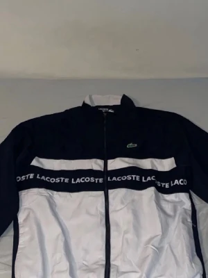 Lacoste Tracksuit Marinblå - Marinblå och vit Lacoste tracksuit i storlek XS. Den är i jättebra skick och bara använd fåtal gånger.