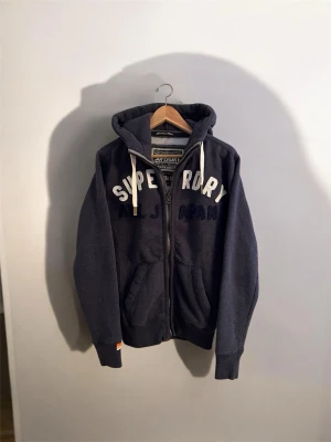 Superdry Zip Hoodie - Säljer denna extremt schyssta Superdry Zip Hoodie i storlek Xs men passar mer S | Väldigt bra skick och inga defekter | Priset går att diskuteras vid en smidig affär. Hör gärna av dig vid frågor eller funderingar👏🏼
