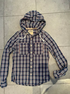 Rutig overshirt med huva från Hollister - Den är i storlek S och sitter riktigt bra. Den är i mycket bra skick och bra kvalitet. Gjord på 100% bomull. Priset går att diskutera!