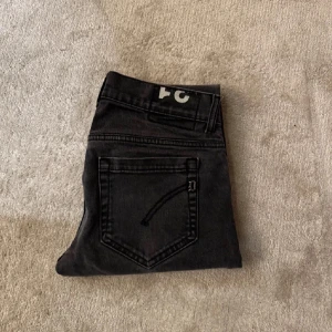 Svarta dondup jeans   - Snygga svarta jeans från dondup i modellen George och storlek 31. De har en klassisk femficksdesign och är perfekta för en stilren look. Passar bra till både vardag och mer uppklädda tillfällen.