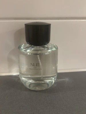 Zara Nuit Night Collection parfym - En stilren parfym från Zara Night Collection med namnet Nuit. Flaskan är rund och genomskinlig med svart cylinderformad kork. Modern och enkel design som passar perfekt på hyllan. Flaskan är i glas och korken i plast.