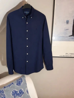 Marinblå skjorta från Ralph Lauren - En riktigt stilig Marinblå skjorta från Ralph Lauren   Storlek: Large.    Skick: 9/10. Skjortan är iprincip helt ny.                                                                         Har ni några frågor eller prisförslag är det bara att höra av sig