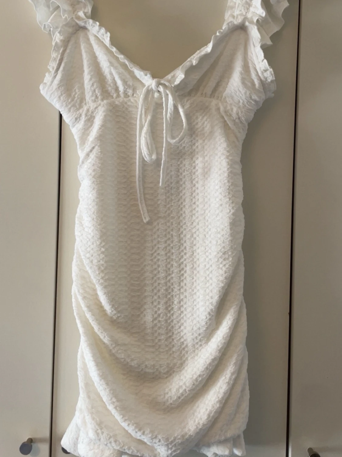 Vit kortklänning med volang och knyt