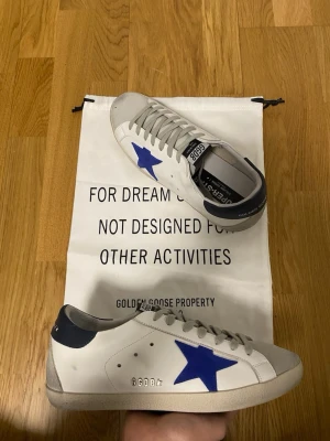 Golden Goose - Ett par skitsnygga Golden Goose i storlek 42!🌟 Mörkblå häl och Blå stjärna! De är i otroligt bra skick, bara använda ett fåtal gånger! OG Dustbag fås med! Kvitto/orderbekräftelse finns 🙏