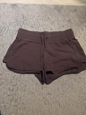 Bruna mjukisshorts med snörning - Mysiga bruna shorts i mjuk bomull med bred resår i midjan och snörning framtill. Shortsen har en bakficka. Perfekta för chill dagar eller träning.