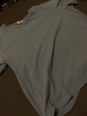 Ljusblå basic t-shirt - En enkel och stilren ljusblå t-shirt med rund hals och korta ärmar. Perfekt till jeans eller shorts för en clean look. Tillverkad i mjuk bomull som känns skön mot huden.