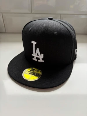New Era LA keps - Svart LA 59Fifty keps från New Era, kepsen är i nytt skick och aldrig använd. Storlek 7 (55,8cm).
