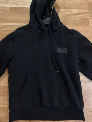 Svart hoddie från Jack&jones - Hej säljer denna svarta hoddie från Jack and Jones då den har blivit för liten den passar XS eller liten S som är runt 173. passar perfekt för kyliga sommarkvällar!