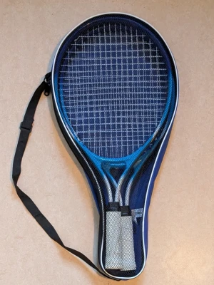 Blått tennisracketset med fodral,  TRETORN IKEA - Rare Limited Edition Tretorn tennis or racketball racket made for IKEA FAMILY. Två tennisracketar med vita handtag, levereras i ett matchande blått fodral med axelrem. Perfekt för att ta med till tennisbanan eller parken. Racketarna har klassiskt rutmönstrat nät.