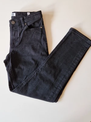 Jack & Jones jeans - Snygga svarta skinny jeans från Jack & Jones med klassisk femficksdesign och smal passform. Jeansen har normal midja, dragkedjegylf och är tillverkade i denim för extra komfort. Använda ett fåtal gånget utan tecken på slitage. Storlek 152 i modellen sli