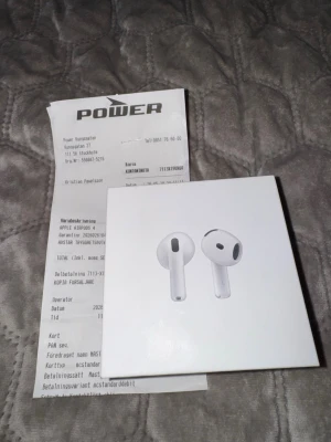 Apple AirPods 4 trådlösa hörlurar helt nya med kvitto - Säljer ett par Apple AirPods 4 med laddningsetui. Hörlurarna är vita och har en stilren, minimalistisk design i plast. Perfekta för dig som vill ha grymt ljud och smidig anslutning till din iPhone eller andra Apple-enheter. Levereras i originalförpackning.helt nya med kvitto 