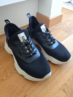 Svarta sneakers från Steve Madden - Svarta Steve Madden skor med vit sula och svart mesh-överdel. Skorna har svarta snören med snabblås. Älskar dessa, köpte de förra våren och använt de en del. Säljer de däremot då de är lite för små. 37:or men små i storleken. Passar nog någon med 36 eller 36 ½ bättre. 
