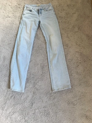 Ljusblå baggy jeans från Madlady - Säljer ett par ljusblå jeans från Madlady med baggy passform och klassisk femficksdesign. Jeansen har låg midja och är tillverkade i denim med snygga kontrastsömmar. Perfekta för en avslappnad och trendig look.